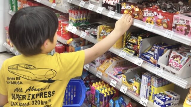 スーパーのお菓子売り場を物色する男の子